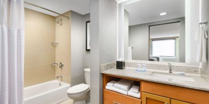 Guest bathroom with shower and tub at Hyatt HOUSE Fort Lauderdale Airport-South & Cruise Port.
