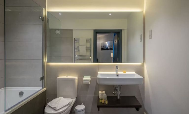 Private guest bathroom with combined shower at Pelican London Residence & Hotel.and tub 