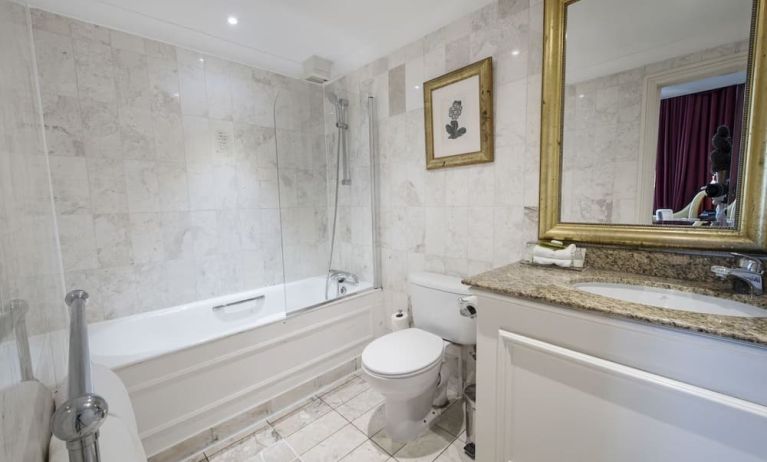 Private guest bathroom with combined tub and shower at The Colonnade Hotel.