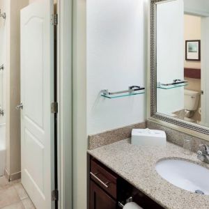 Guest bathroom with shower and tub at Residence Inn By Marriott Hattiesburg.