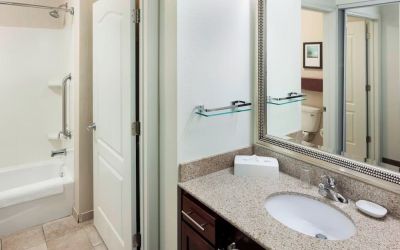 Guest bathroom with shower and tub at Residence Inn By Marriott Hattiesburg.