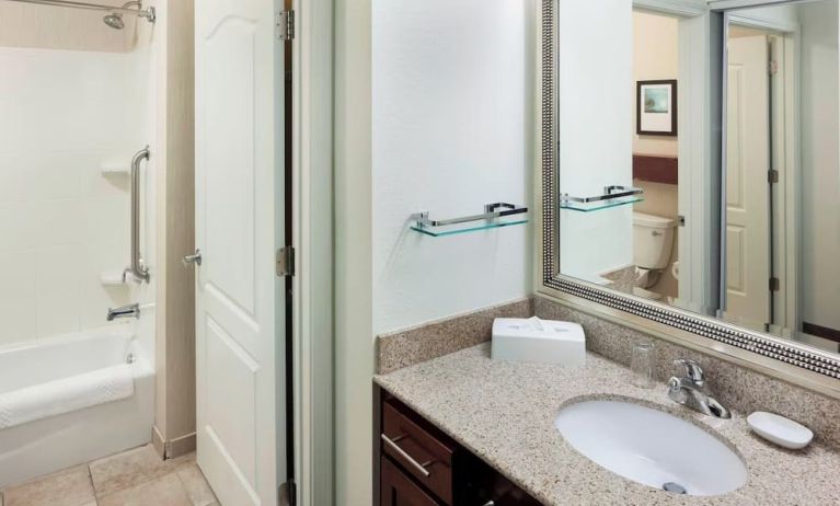 Guest bathroom with shower and tub at Residence Inn By Marriott Hattiesburg.