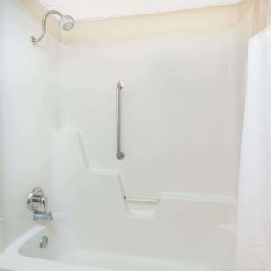 Guest bathroom with shower and tub at Blue Way Inn & Suites Wichita East.