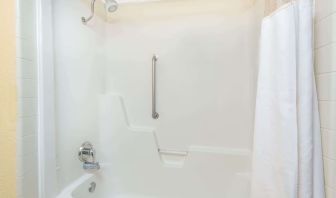 Guest bathroom with shower and tub at Blue Way Inn & Suites Wichita East.