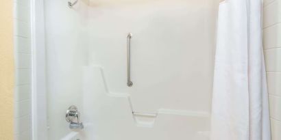 Guest bathroom with shower and tub at Blue Way Inn & Suites Wichita East.