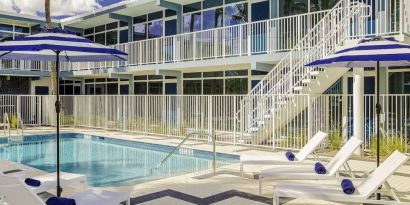 Refreshing outdoor pool and sun loungers at Plunge Beach Resort.