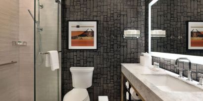 Guest bathroom with shower at The Slate Denver, Tapestry Collection By Hilton.
