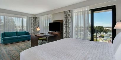 Day use room with work desk, sofa and balcony at Hampton Inn & Suites Sunnyvale Silicon Valley.