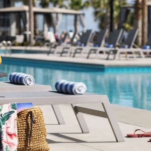 Sun loungers surrounding the pool at Embassy Suites By Hilton Myrtle Beach Oceanfront Resort.