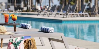Sun loungers surrounding the pool at Embassy Suites By Hilton Myrtle Beach Oceanfront Resort.