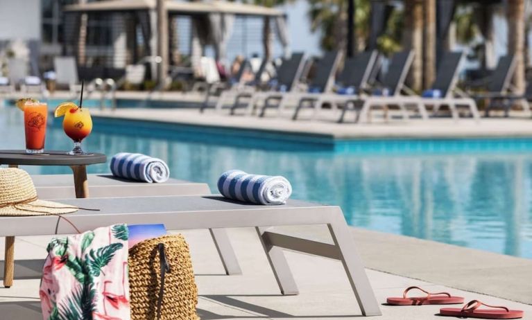 Sun loungers surrounding the pool at Embassy Suites By Hilton Myrtle Beach Oceanfront Resort.