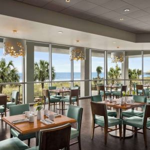 Dining area with natural light perfect for coworking at Embassy Suites By Hilton Myrtle Beach Oceanfront Resort.
