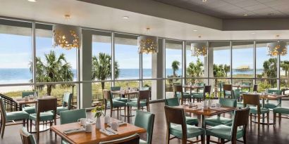 Dining area with natural light perfect for coworking at Embassy Suites By Hilton Myrtle Beach Oceanfront Resort.