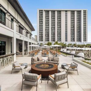 Firepit and plenty of outdoor seats near pool area at Embassy Suites By Hilton Myrtle Beach Oceanfront Resort.