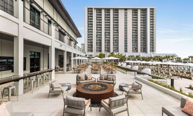 Firepit and plenty of outdoor seats near pool area at Embassy Suites By Hilton Myrtle Beach Oceanfront Resort.