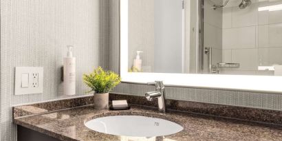 Guest bathroom with shower at Embassy Suites By Hilton Los Angeles International Airport South.