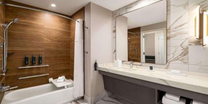 Private guest bathroom with tub at Hilton BNA Nashville Airport Terminal.
