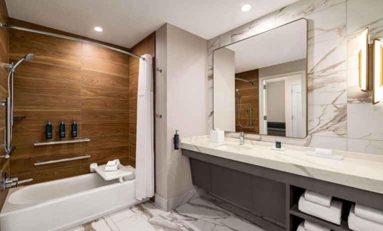 Private guest bathroom with tub at Hilton BNA Nashville Airport Terminal.
