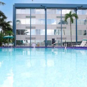 Relaxing outdoor pool with lounge area at EnVision Hotel Miami International Airport.
