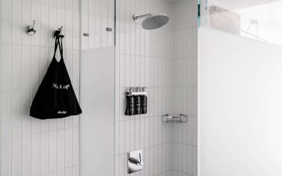 Private guest bathroom with shower and free toiletries at Arlo SoHo.