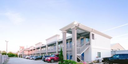 Hotel exterior and parking area at Express Inn - Spring.