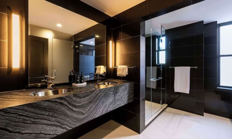Private guest bathroom with shower and free toiletries at The Benjamin Royal Sonesta New York.