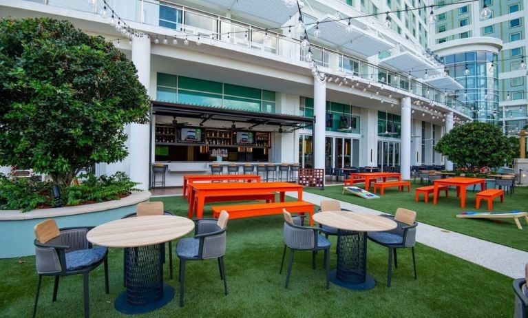 Alfresco dining and lounge area beside a bar at Hilton Orlando.