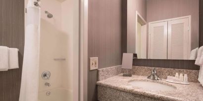 Private guest bathroom with shower and free toiletries at Sonesta Select Tempe Downtown.