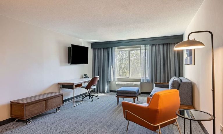 Day use deluxe room's living area with work desk and comfortable seating at Sonesta Select Pleasant Hill.