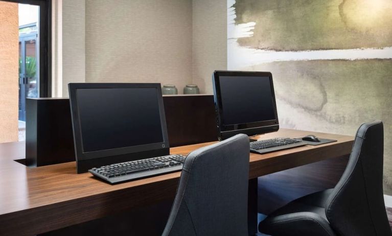 Business center with computers and ergonomic chairs at Sonesta Select Phoenix Camelback.