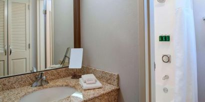 Private guest bathroom with combined shower and tub at Sonesta Select Kansas City Airport Tiffany Springs.
