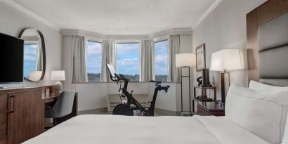 Day use room with work desk and Peloton bike at Hilton Crystal City At Washington Reagan National Airport.