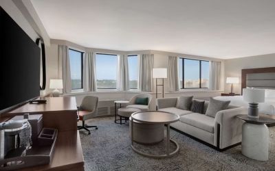 Beautiful king suite with work desk, TV, and sofa at Hilton Crystal City At Washington Reagan National Airport.