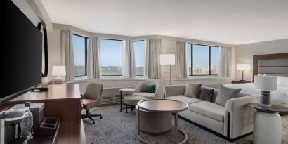 Beautiful king suite with work desk, TV, and sofa at Hilton Crystal City At Washington Reagan National Airport.
