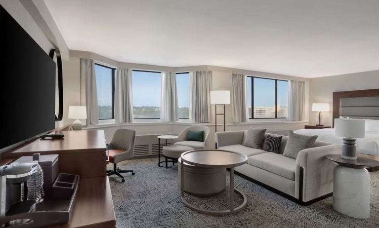 Beautiful king suite with work desk, TV, and sofa at Hilton Crystal City At Washington Reagan National Airport.