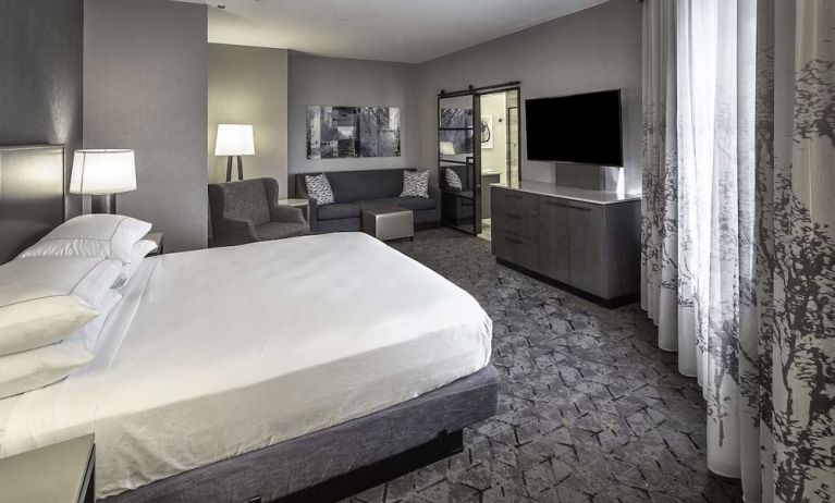 King size bed and sofa in a day use room at DoubleTree By Hilton Modesto.