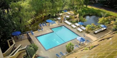 Seasonal outdoor pool and jacuzzi surrounded by sun loungers at Hilton Bellevue.
