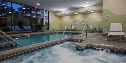 Relaxing indoor pool with lounge chairs at Sonesta Milwaukee West Wauwatosa.