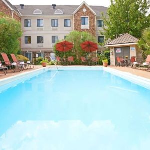 Outdoor pool with lounge chairs at Sonesta ES Suites Dallas Las Colinas.