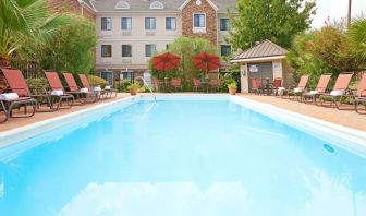 Outdoor pool with lounge chairs at Sonesta ES Suites Dallas Las Colinas.