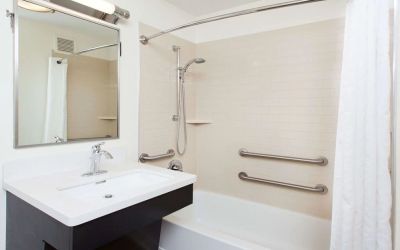 Private guest bathroom with combined shower and tub at Sonesta Simply Suites Dallas Las Colinas.