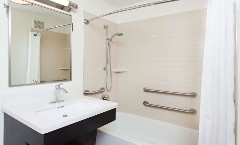Private guest bathroom with combined shower and tub at Sonesta Simply Suites Dallas Las Colinas.