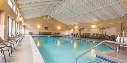 Refreshing indoor pool surrounded by loungers at DoubleTree By Hilton Grand Rapids Airport.