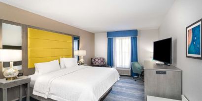 King size bed with work desk at Hampton Inn & Suites Amelia Island-Historic Harbor Front.