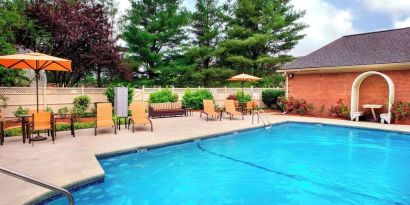 Outdoor pool with lounge seating at Sonesta Select Tinton Falls Eatontown.