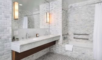 Private guest bathroom with combined shower and tub at Nautilus Sonesta Miami Beach.