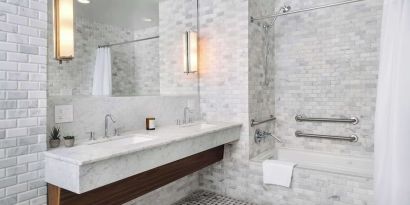 Private guest bathroom with combined shower and tub at Nautilus Sonesta Miami Beach.