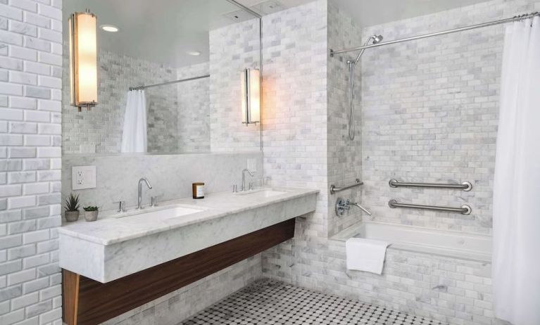 Private guest bathroom with combined shower and tub at Nautilus Sonesta Miami Beach.