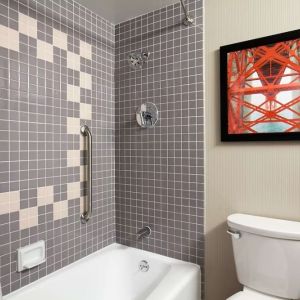 Guest bathroom with shower and tub at Embassy Suites By Hilton San Francisco Airport Waterfront.