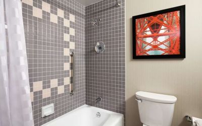 Guest bathroom with shower and tub at Embassy Suites By Hilton San Francisco Airport Waterfront.